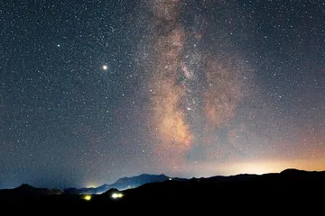 The Milky Way stretching over a mountain ridge at night