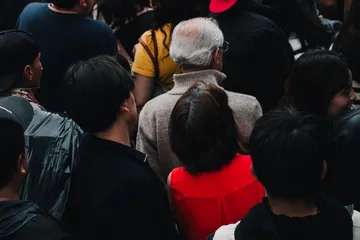 Crowd of people seen from behind in a busy street